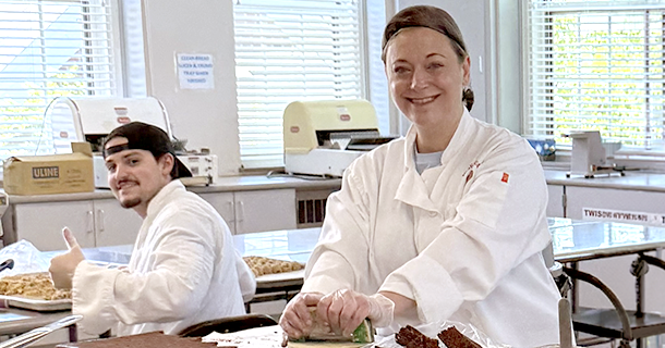 Two employees volunteering making sweets at Misericordia.