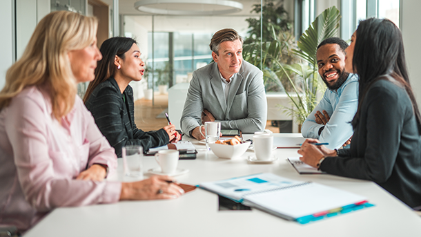Diverse group of employees gathered around a conference room table