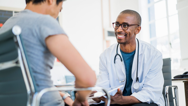 Healthcare provider using a tablet when talking to a patient