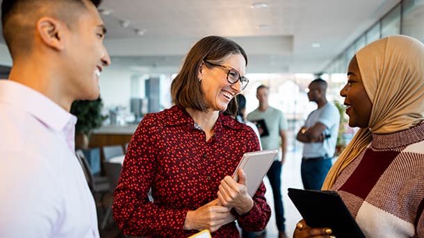 Office workers standing in a group talking.