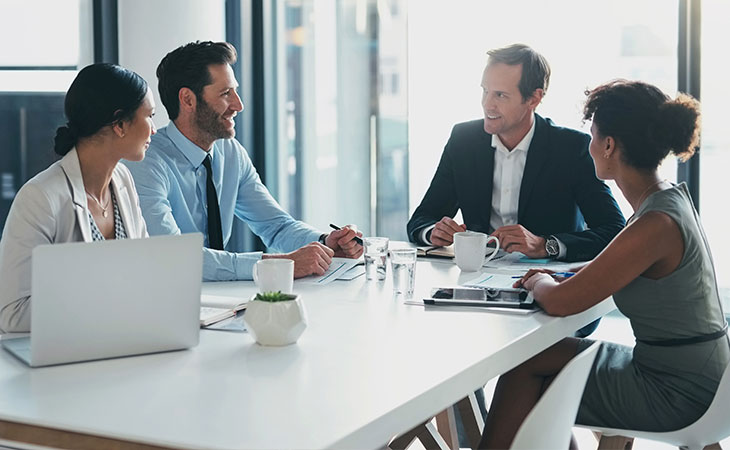 Employees sitting around conference table.